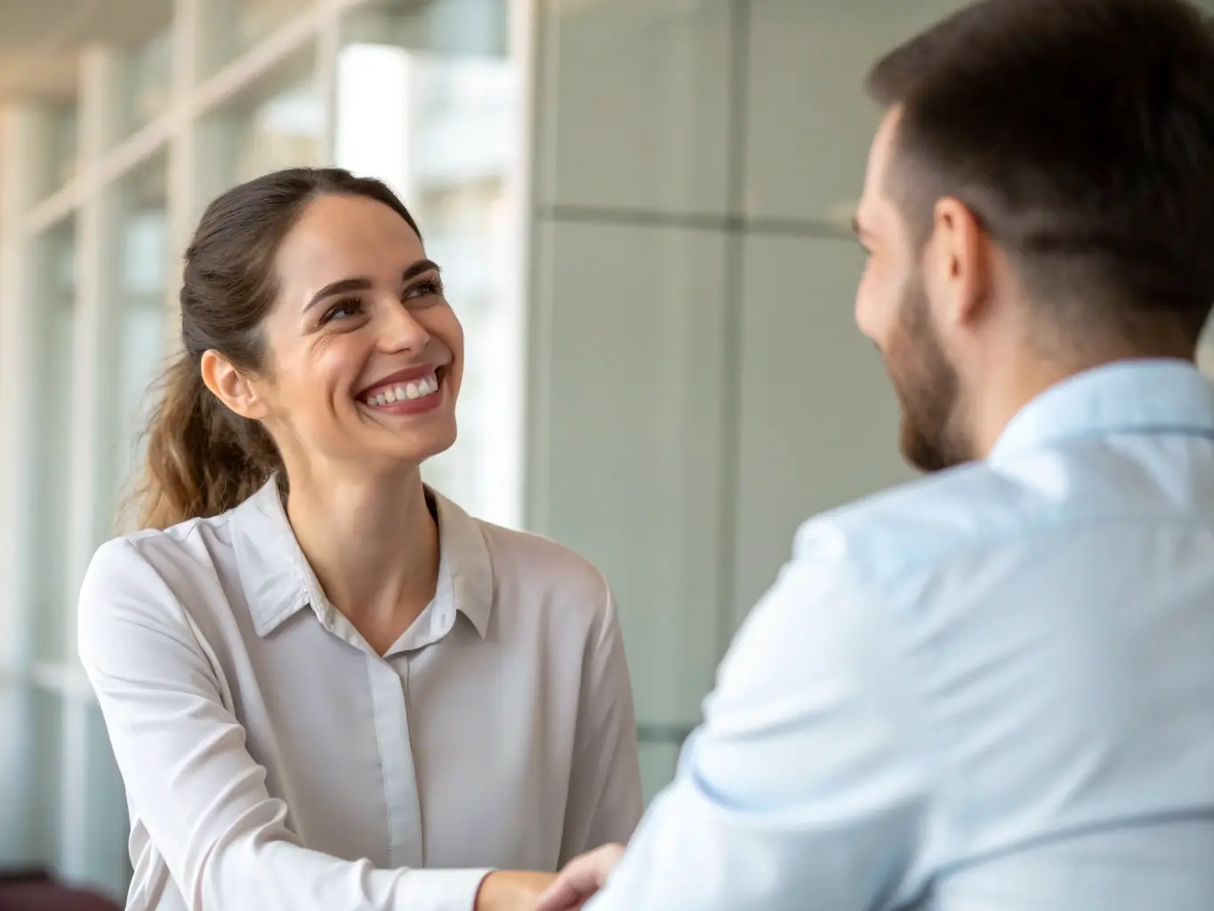 A close-up shot of a lawyer shaking hands with a client, signifying trust, partnership, and client satisfaction in legal services.